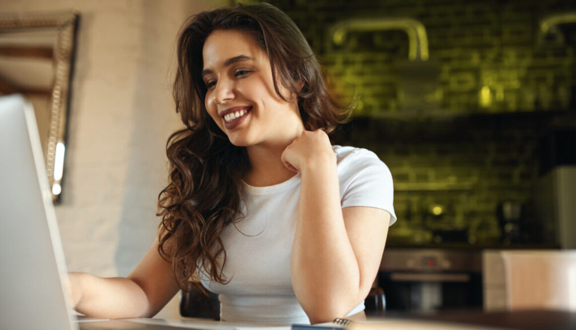 Mulher sorrindo enquanto navega em um site, representando a experiência de atendimento personalizado no site.